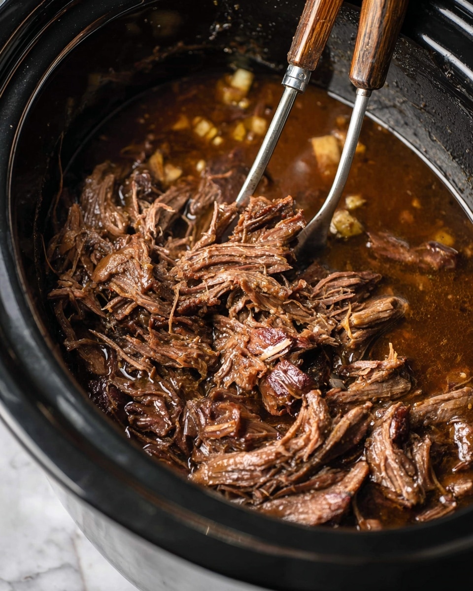 A white plate on a white marbled surface holds a serving of creamy mashed potatoes as the bottom layer, smooth and pale in color. On top of the mashed potatoes is a thick layer of shredded brown pot roast, garnished with small green herbs for a touch of color. To the side of the main stack is a mix of cooked vegetables, including orange carrot slices and green beans, adding bright pops of color to the plate. The scene is casual, with a glimpse of a fork nearby and a stainless steel slow cooker blurred in the background. The overall look is warm and inviting. photo taken with an iphone --ar 4:5 --v 7
