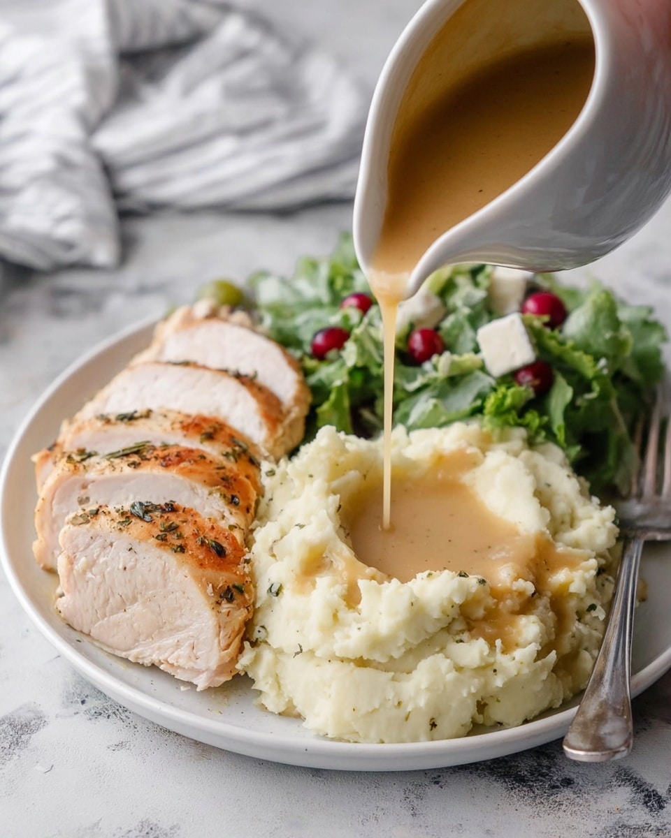 A white plate on a white marbled texture holds a meal with three main parts. On the left, there are four slices of roasted turkey breast, light beige inside with a golden brown, slightly crispy skin sprinkled with herbs. In the center front, a large mound of creamy mashed potatoes with a smooth and fluffy texture has a hollow filled with light brown gravy being poured from a white gravy boat. On the right, there is a small green salad with leafy greens, some red berries, and a few small white cheese pieces. A silver fork rests on the right side of the plate, and a woman's hand is pouring the gravy. Photo taken with an iphone --ar 4:5 --v 7