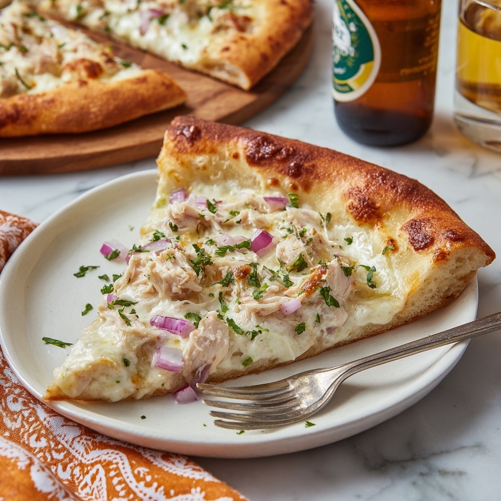 The image shows a white flat rectangular pizza cut into small square slices, placed on a light brown wooden board over a white marbled surface. The pizza has a thin crust that is pale with slightly golden edges. The base layer is covered with melted white cheese that is creamy and smooth, with small patches of light brown where the cheese is baked. On top of the cheese are pieces of cooked chicken that are pale beige and slightly browned, along with finely chopped red onions scattered evenly. The pizza is also sprinkled with fresh green parsley and dark dried herbs for garnish across all slices. photo taken with an iphone --ar 4:5 --v 7