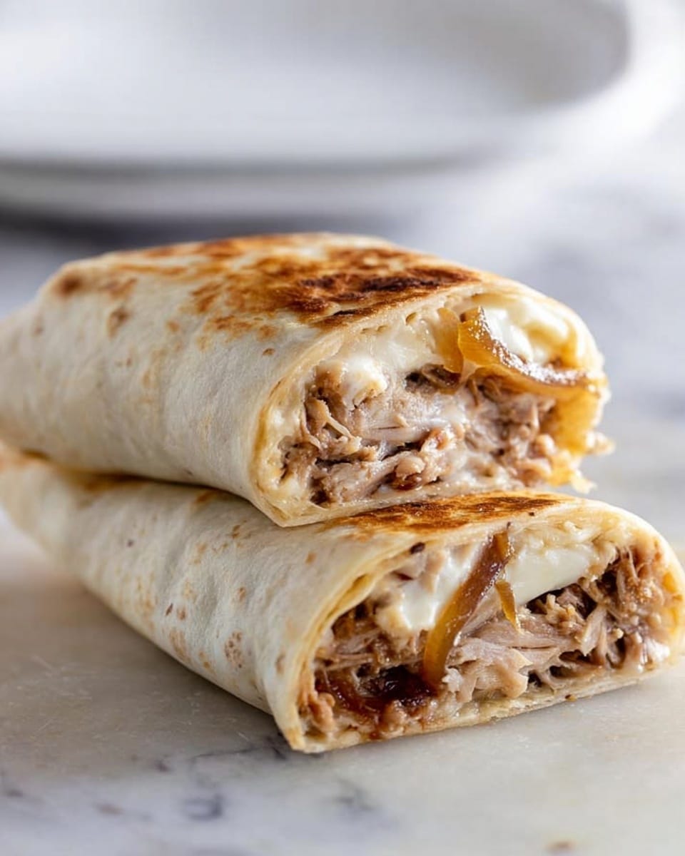 The image shows two halves of a wrap sandwich stacked on a white marbled surface. The wrap is light beige with slight browning from toasting. Inside, there are several visible layers: a layer of pulled meat that is brown and tender, a melted white cheese layer that looks soft and creamy, and some caramelized onions with a golden-brown color and slightly sticky texture. The wrap edges are soft and slightly torn from being cut, and the filling is tightly packed inside. In the background, there is a white plate that is out of focus. Photo taken with an iphone --ar 4:5 --v 7