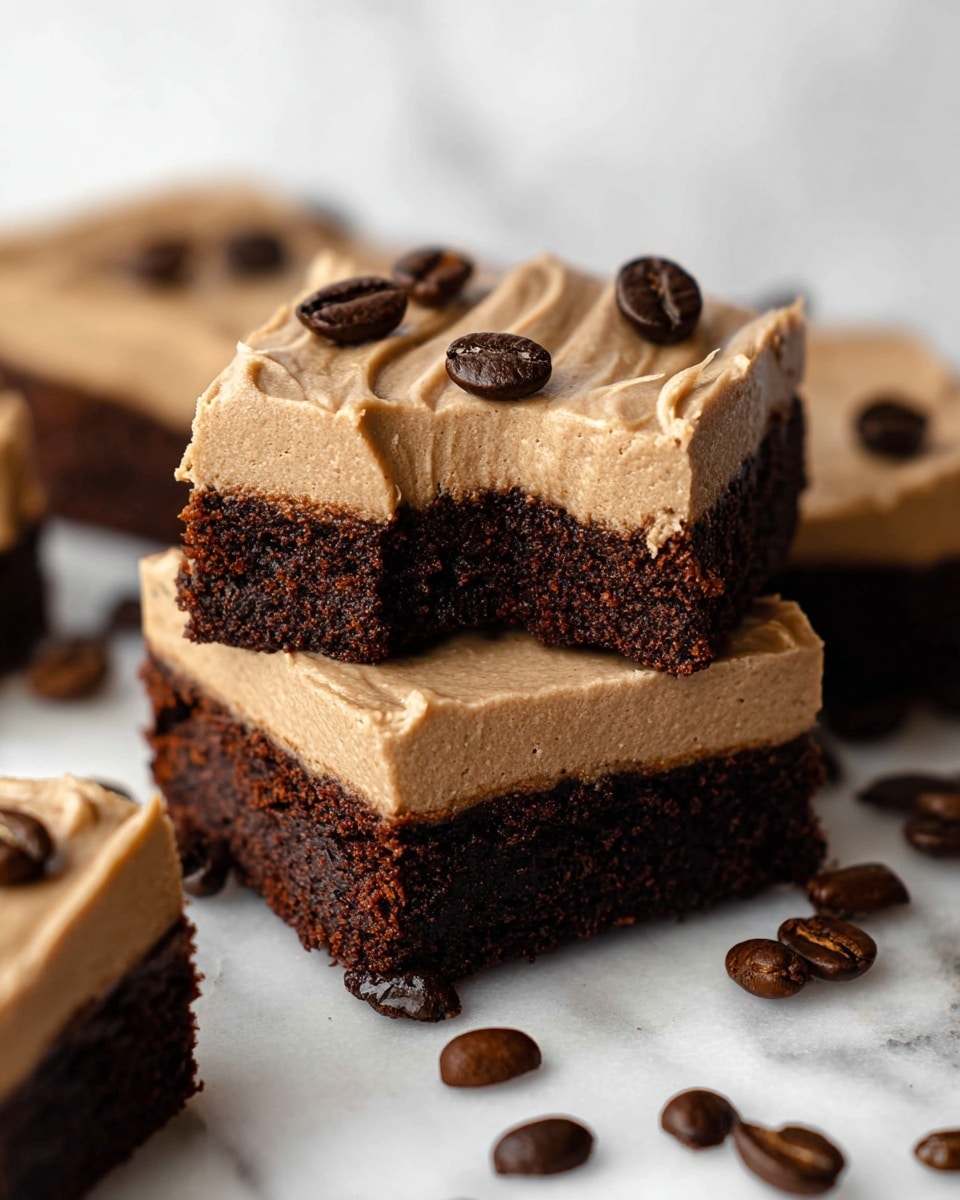The image shows square brownies with two layers on a white marbled surface. The bottom layer is a dark brown, moist chocolate base with a textured, slightly crumbly look. The top layer is a smooth, creamy light brown frosting that is evenly spread with gentle ridges. Each brownie has three dark brown coffee beans placed on top as decoration. Around the brownies, whole coffee beans are scattered casually, adding detail and enhancing the coffee theme. Photo taken with an iphone --ar 4:5 --v 7