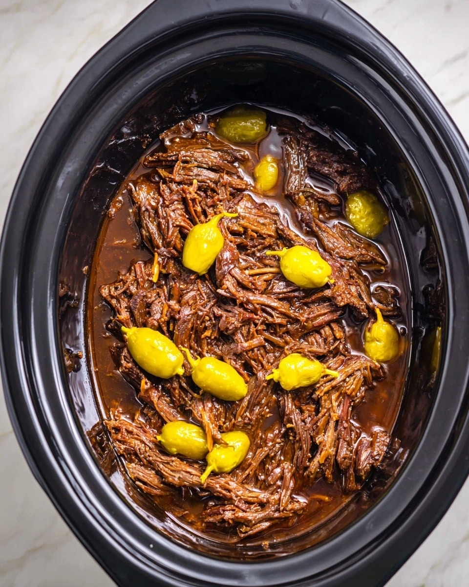 A white plate holds four small sandwiches stacked close together on a white marbled surface with a red checkered cloth underneath. Each sandwich has three layers: a shiny, golden-brown top bun speckled with herbs, a middle layer of thin yellow pepper slices and melted light yellow cheese, and a bottom layer of dark, juicy shredded meat. One sandwich is positioned on top of the others, showing the inside clearly. A pale green glass is blurred in the background. Photo taken with an iphone --ar 4:5 --v 7
