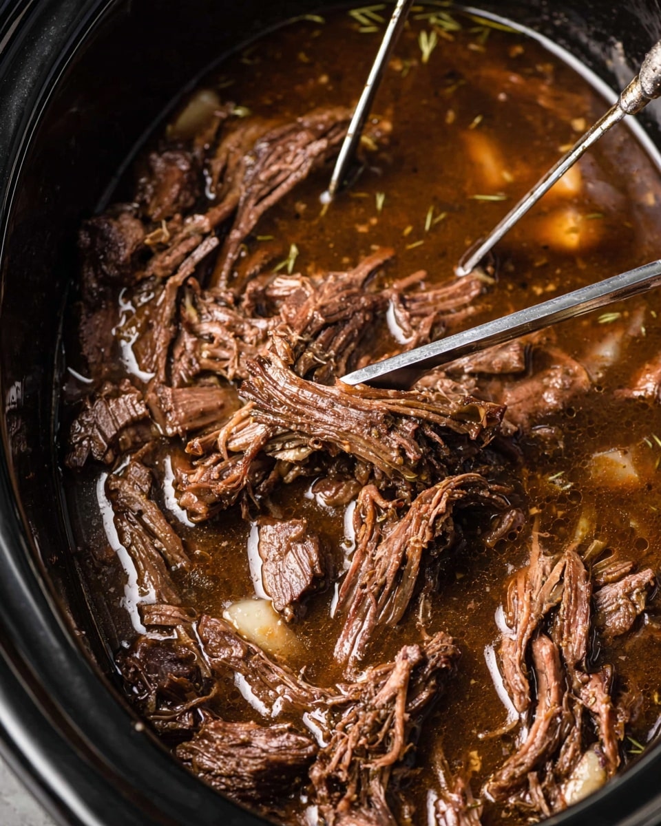 A white plate with three main layers sits on a beige cloth over a white marbled surface; the bottom layer is a creamy mound of mashed potatoes with a soft, smooth texture, topped by a generous heap of dark brown, shredded beef mixed with sauce and garnished with small green herb pieces. To the left of the mashed potato and beef stack is a colorful side of mixed vegetables, including bright green beans, orange carrot slices, and yellow corn kernels, all glistening slightly. In the background, a silver slow cooker with a black dial is blurred out, and a fork rests to the upper right of the plate. photo taken with an iphone --ar 4:5 --v 7