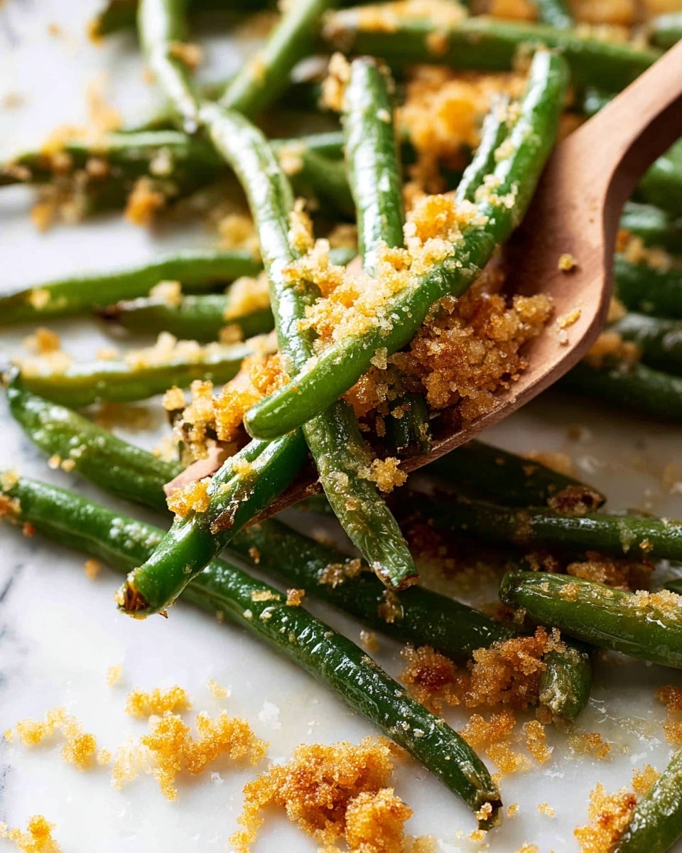 A close-up view of a white scalloped plate filled with cooked green beans that look slightly wrinkled and roasted. The green beans are covered with a light layer of crumbly, golden-brown bits which add a crunchy texture. The beans vary in color from bright green to a darker roasted green, showing a mix of tender and crispy parts. The plate rests on a wooden surface with a blurred white cloth in the background, giving a warm and homemade feel. photo taken with an iphone --ar 4:5 --v 7