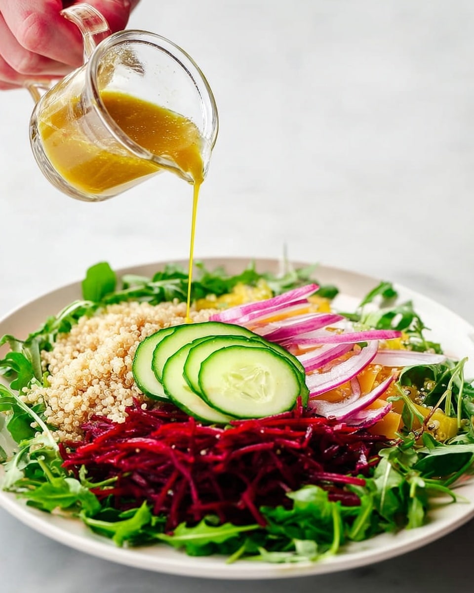 A white plate holds a colorful salad arranged in layers on a white marbled surface background. The bottom layer is fresh green arugula leaves spread across the plate, topped with a ring of shredded deep red beets. Inside the beet ring, there is a layer of light brown cooked quinoa with a slightly grainy texture. On top of the quinoa, several thin slices of cucumber with dark green skin and white flesh are placed in a circular pattern, and a few thin rings of purple-red onion rest on top of the cucumber. A woman's hand is shown pouring a golden yellow dressing from a small clear glass jug onto the salad. Photo taken with an iphone --ar 4:5 --v 7